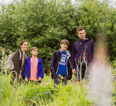 Family enjoying plants in Pollinator Pathmaker artwork
